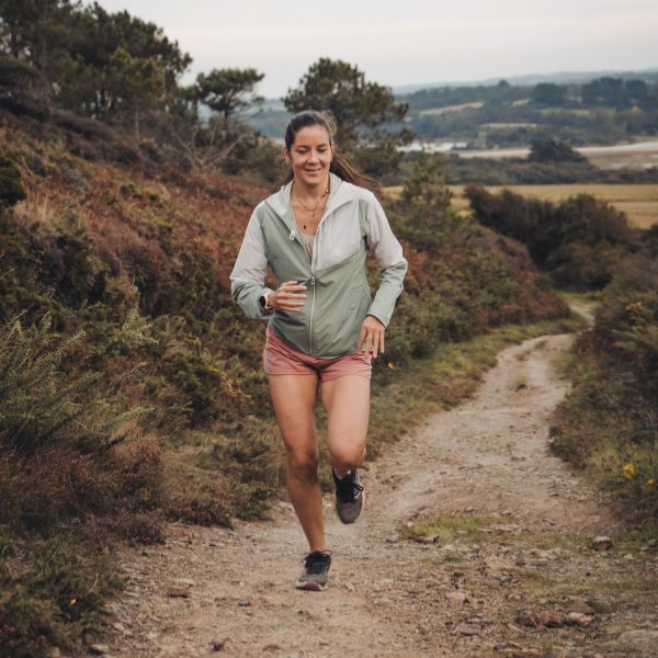 Vannaly courant lors d'un coaching en course à pied sur un chemin naturel bordé de verdure